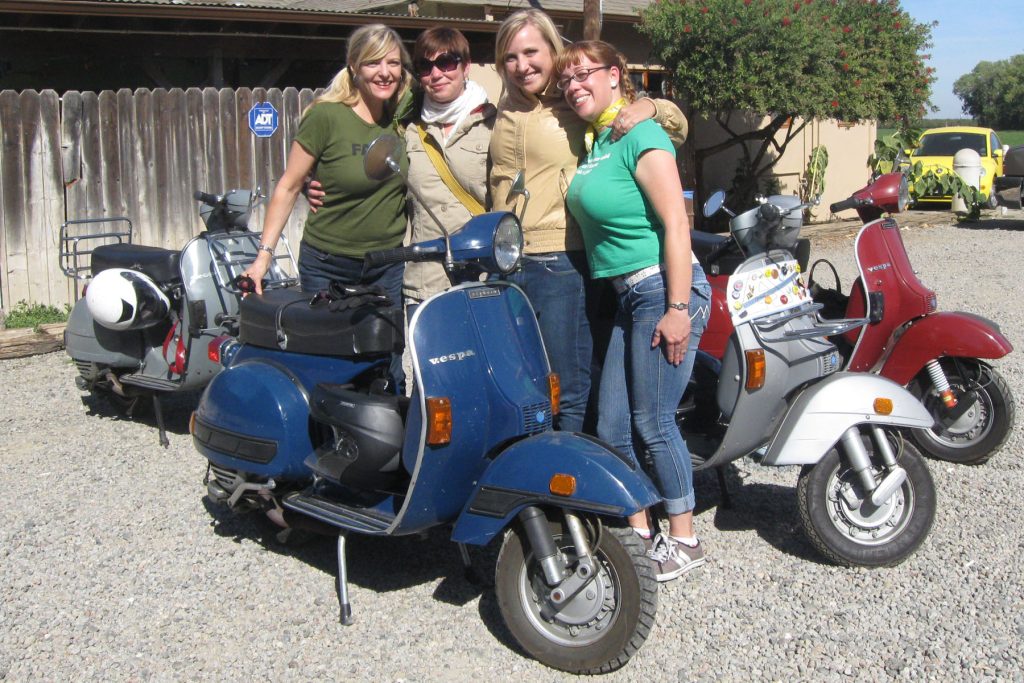 Four women riders with the Girl Scoots of America stand next to vintage Vespa motor scooters in Sacramento, CA circa 2012, photo ©Autumn Brown